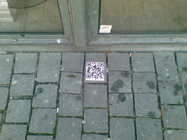 Picture of a QR code sticker by a shop window in Breda