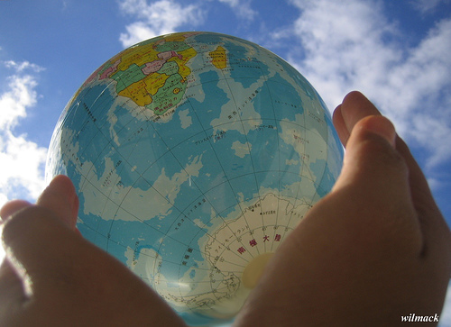 Two hands holding up a globe